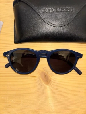 Blå solglasögon från John Henric - Tjena! Säljer ett par snygga solglasögon från John Henric i mörkblå färg med svart glas! Skick 9/10. Bara att fråga om det är något!