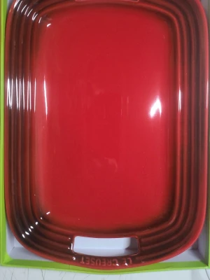 Röd ugnsform från Le Creuset - Säljer en snygg röd ugnsform från Le Creuset i keramik. Formen är rektangulär med praktiska handtag på sidorna och har lock. Perfekt för matlagning och servering. Klassisk design och tåligt material.