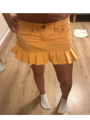 Aprikosfärgad jeanskjol - Superfin jeanskjol med volangkant nertill. På första bilden ser färgen lite konstig ut men det var svårt att få till i ljuset hur färgen egentligen är. Den är lite mer åt pastell orange/ aprikos färgad. Sytt den själv. 