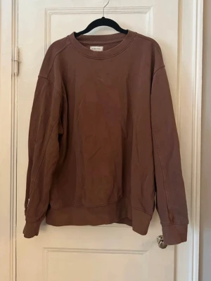 Brun oversized sweatshirt - En enkel och oversized brun sweatshirt med rund halsringning och ribbade muddar vid ärmar och nederkant. Perfekt för en avslappnad och chill stil. Tillverkad i mjukt material för extra komfort.
