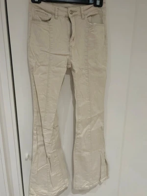 Beige jeans  - Jeans i beige färg & med slits nere i benet & detalj längst benet