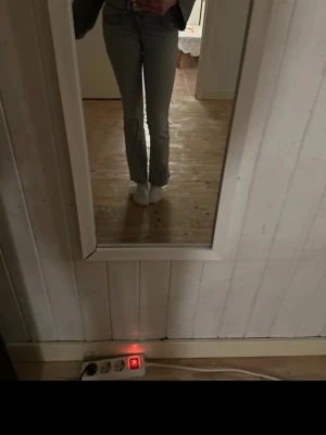 Grå raka jeans med vintagekänsla - Säljer ett par grå jeans med rak passform och klassisk femficksdesign. Jeansen har en snygg tvättad look som ger en vintage vibe och passar perfekt till en avslappnad stil. Materialet är denim och de har normal midja. Perfekta för dig som gillar tidlös och enkel look.