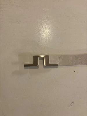 Vitt läderbälte från J.LINDEBERG - Snyggt vitt bälte i äkta läder med ett stilrent och modernt metallspänne i silverfärg. Bältet har en clean look och är tillverkat i Italien. Perfekt accessoar för att lyfta din outfit. Storlek 95 cm. Skick 10/10 (knappt använt)