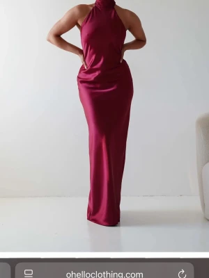Vinröd balklänning i satin - Snygg vinröd långklänning i satin med halterneck med öppen rygg och figurnära passform. Den kommer från oh hello clothing och är enbart testad. Den är bra i längd på mig som är 170 cm💞