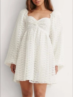 Vit klänning - Supersöt vit kortklänning med blommigt mönster och volangiga långa ärmar. Klänningen har en söt v-ringning och lätt utställd kjol. Perfekt för sommarens alla tillfällen eller studenten! Inga defekter. Storlek Xs men passar mer en storlek S då den är stretchig i ryggen