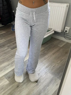 Ljusgrå utsvängda mjukisbyxor - Säljer ett par ljusgrå mjukisbyxor med bred resår i midjan från H&M. Nästan aldrig använda 