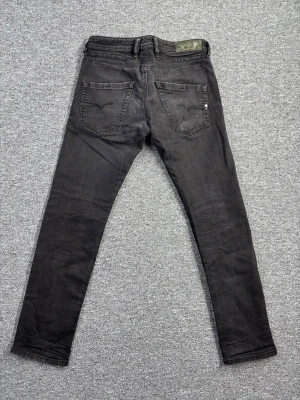 Vintage Diesel Jeans 30/32 – Straight Slim Fit – Faded Black Denim – Y2K - Riktigt snygga vintage Diesel jeans i straight/slim fit med mörk tvätt och subtila fades 🔥 • Märke: Diesel • Storlek: 30/32 • Passform: Straight / Slim fit • Vintage • Faded black wash • Clean men med karaktär Perfekt modell om du vill ha en mer stilren siluett men fortfarande vintage-känsla. Funkar både casual och uppklätt. Diesel från den här eran har riktigt bra denimkvalitet och passform. 📏 Måtten visas i bilderna. Skick: Bra vintage skick (se bilder).