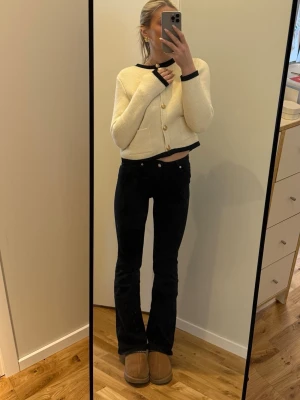 Svarta bootcut jeans med låg midja - Säljer ett par svarta bootcut jeans med låg midja. Jeansen har en tight passform upptill och utsvängda ben. Perfekta för en trendig och avslappnad look.
