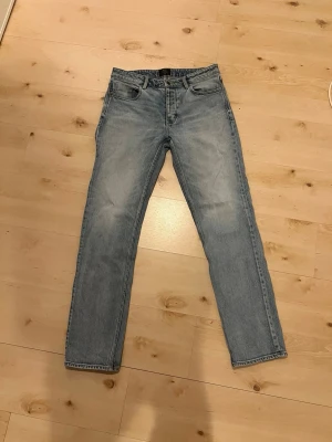 NEUW Jeans - Säljer ett par ljusblå jeans med rak passform och klassisk femficksdesign. Jeansen har normal midja och är tillverkade i denim med en snygg tvättad look. Perfekta till en avslappnad stil och passar till det mesta i garderoben.