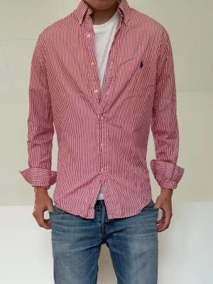 Rosa randig Ralph Lauren skjorta - Rosa randig Ralph Lauren skjorta i strl M men sitter som en S! Mycket bra skivk utan nåra defekter och hör gärna av er vid frågor elr funderingar!!