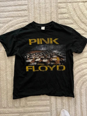 Svart Pink Floyd t-shirt - Cool svart t-shirt med stort tryck av Pink Floyd och ett ikoniskt motiv på framsidan. Köpt i köpenhamn.