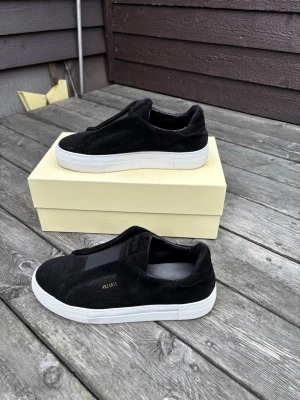  Axel Arigato skor - Säljer ett par Dice Laceless Sneakers i storlek 40.  Skorna är i nyskick aldrig avänts innan dessutom säljs inte skorna längre vilket gör den sällsynt härmed lite dyrare pris. de är i princip helt nya. Nypris är cirka 3 000 kr, och med tanke på skicket säljs de för 2500kr. Pris kan diskuteras. Perfekt för dig som vill ha ett par stilrena premiumsneakers till ett betydligt lägre pris än i butik.  Pris: 2500kr Storlek: 40 Skick: fabriksnya