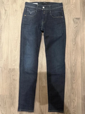 Replay Anbass Hyperflex Dry Jeans Mörkblå W29/L32 - Slim Fit - Replay Anbass Hyperflex Dry mörkblå jeans i stretchig Hyperflex denim med slim fit passform som sitter snyggt och bekvämt och funkar till allt, storlek W29/L32, midja 36,5 cm, ytterbenslängd 105 cm, benöppning 15 cm, modellen är 185cm & väger 65kg, i fint skick.