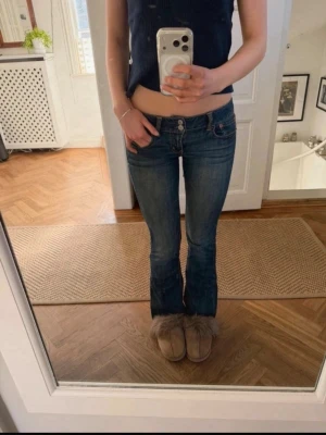 Blå bootcut jeans från American Eagle - Säljer ett par blå bootcut jeans från American Eagle med låg midja och klassiska fickor. Storlek 0. 