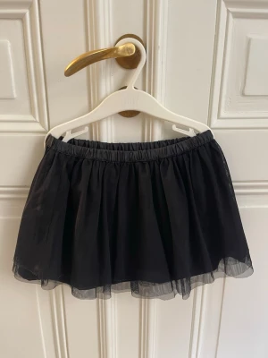 Svart tyllkjol från Terranova - Säljer en svart kortkjol från Terranova med flera lager tyll som ger en fluffig och voluminös look. Kjolen har resår i midjan för skön passform och passar perfekt till dig som vill ha en enkel men snygg kjol.