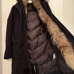 Svart parkajacka från Woolrich small  - Sparsamt använd WOOLRICH damjacka i fint skick. Svart, small/36.  Inga hål eller märken och från rökfritt hem. Finns att hämta på Östermalm eller skickas mot frakt. 