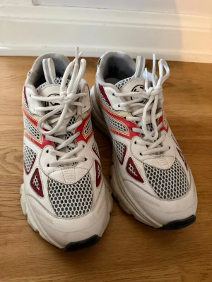 Axel Arigato Marathon runners - Snygga sneakers från Kappa i vitt med röda och grå detaljer. Ovandelen har meshpaneler för extra ventilation och cool look. Klassisk snörning och chunky sula ger retrovibbar. Perfekta för dig som gillar sportig stil och streetwear. Mycket bra skick!! Knappt använda