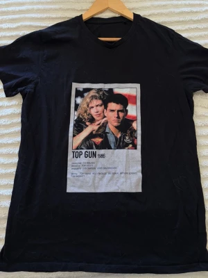 Svart Top Gun t-shirt med tryck - Säljer en svart egentryckt t-shirt med stort Top Gun 1986-tryck på framsidan i storlek L.