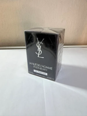 YSL La Nuit De L'Homme Le Parfum 100ml - La Nuit De L'Homme Le Parfum från Yves Saint Laurent är en elegant herrparfym i svart, stilren kartong med silverdetaljer. Flaskan rymmer 100 ml och doften är känd för sin intensiva och sofistikerade karaktär. Perfekt för dig som gillar lyxiga och klassiska parfymer.