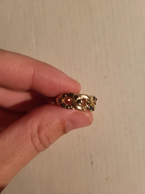 Gold coloured ring - Ring with interlocking chain design. Black coloured gemstones inlaid in every other link.  Inside diameter ~16mm  Total diameter 27mm   Bundle discounts: two items 5% off (automatic) three items 10% off, five items 20% off. Message me before purchasing 3+ items for discount.
