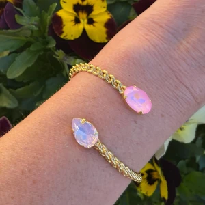 Bangle armband rosa - Armband, Bangle, i guldpläterad mässing med kristaller. Kristaller Pear 14mm och Oval 14mm, Färg Powder Rose De Lite och Rose Water Opal. Ställbar storlek. De senare bilderna andra armband som finns i lager. Jag skickar endast spårbart, samfraktar. Fast pris. Besök gärna mina övriga annonser.  Till mina smycken använder jag kristaller från Preciosa, Aurora och Swarowsk.