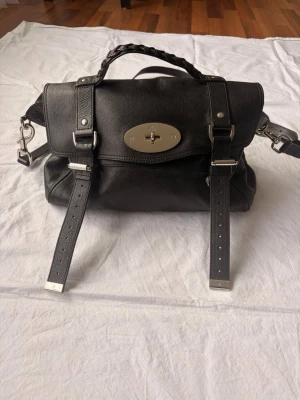 Mulberry Alexa - Mulberry Alexa , köpt 2016 i mulberry butik i Oslo, väldigt fint ny skick, följer med dustbag, kvitto och kuvert. 2016 var sista året denna model tillverkades och den återlanserades 2020 Mått  Höjd 23cm Bredd 33cm