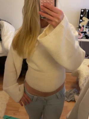 Vit croppad stickad tröja - Säljer en vit croppad stickad tröja med långa ärmar och bred ribbad mudd i midjan. Jättefin till vardags men också som ”slänga på” tröja över ett linne tillexempel. Storlek XS från Ginatricot. Köpt för 300 sälj billigare. Använd fåtal gånger💗