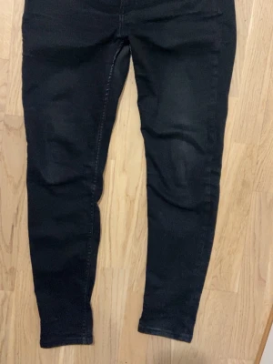 Svarta slim jeans - Säljer ett par svarta slim jeans med klassisk femficksdesign. Jeansen har normal midja och är tillverkade i stretchigt material för extra komfort. Perfekta för en trendig och avslappnad look. Jeansen passar mig som är 1.72m lång men är på väv att bli för små.