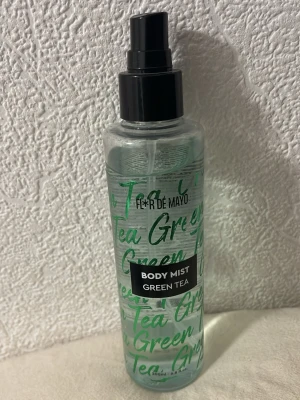 Body Mist Green Tea från Flor de Mayo - Fräsch body mist med doft av grönt te från Flor de Mayo. Kommer i en genomskinlig plastflaska med svart spraykork och grön text. Perfekt för dig som gillar lätta och uppfriskande dofter.