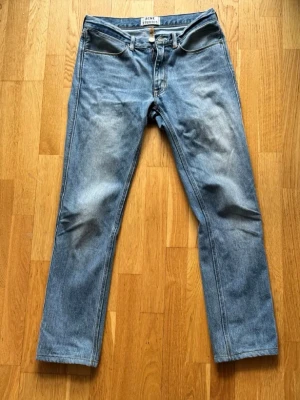 Acne Studios Jeans - Säljer ett par klassiska blå jeans från Acne Studios, modell Max LT Vintage 30x34. Jeansen har rak passform, tillverkade i 100% bomull. Snygg tvätt med lätt slitning på låren för en vintagekänsla.