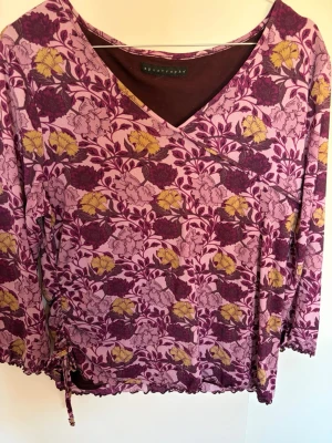 2000s blus  - En superfin vintage 2000s blus från märket ”Apostrophe”. Den är lila med blommor, är V-ringad och har en knytning på högra sidan som en liten detalj. Passar S och M! Priset kan diskuteras💜