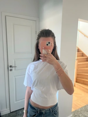 Vit croppad t-shirt - Säljer en enkel och fräsch vit croppad t-shirt med korta ärmar. Toppen har en loose passform och är perfekt till jeans eller kjol. Tillverkad i mjuk bomull för en bekväm känsla. Den är knappt använd och säljer då den inte kommer till användning🥹priset kan diskuteras💕