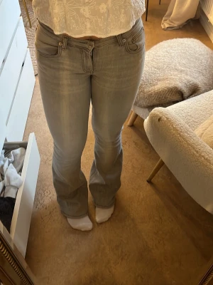 Ljusgrå bootcut jeans - Säljer ett par ljusgrå bootcut jeans med klassisk femficksdesign och normal passform. Jeansen har en lätt utsvängd benslut och är tillverkade i mjukt denimtyg. Köpta på lager 157 för långesedan. 