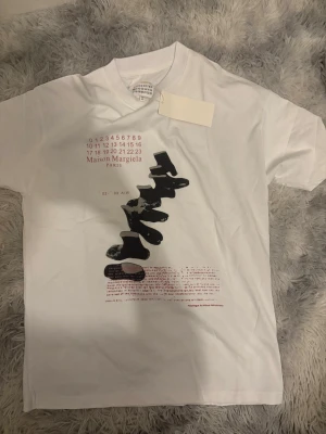 Maison Margiela t-shirt - Maison Margiela t-shirt i vitt storlek 44/S snygg logga. Perfekt för sommaren 100% bomull väldigt skönt material med prislapp kvar