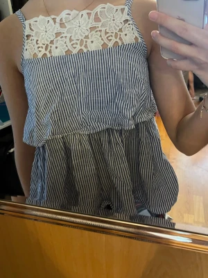 Randig linnetopp med spetsdetalj - Söt blåvit randig linnetopp med vit spets upptill från Zara, bra skick! 