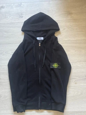 Svart zip hoodie från Stone Island - Svart hoodie från Stone Island med dragkedja framtill och klassisk logopatch på vänster ärm. Inga skador eller så vidare. Storlek S. Riktigt fin zip hoodie