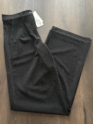 Glittriga kostymbyxor - Glittriga kostymbyxor, raka något vidare ben. Helt ny med prislapp.   Orginalpris 399kr. Helt slutsåld på hemsidan. 💕  Skulle säga att den även passar S.  Perfekt till fest! 💕