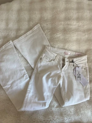 Vita lowrise bootcut jeans - Helt nya vita jeans med snygga slitningar från Gina Tricot med lappen kvar, aldrig använda. De är i storlek xxs och helt slutsålda på hemsidan, därav priset. Har tyvärr ingen bild på hur de sitter på då de var för små men kolla gärna ”14+ low rise flare jeans” på Ginas hemsida🥰 Midjemått:34 och innerbenslängd: 76