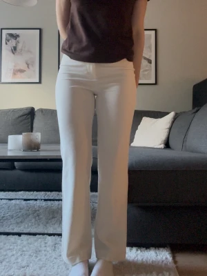 Crémevita kostymbyxor - Snygga oanvända crémevita kostymbyxor med rak passform. Byxorna har minimalistisk design utan synliga detaljer och är perfekta för en clean och stilren look. Passar till både sneakers och klackar. Storlek S, Längd 32. 