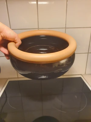 Mique svart skål med beige kant - Mique svart skål med beige kant. Skålen har rund form och är tillverkad i Sverige enligt märkning på den. Passar för servering av exempelvis sallad, frukt eller snacks samt som dekorativ inredningsdetalj.