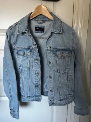Ljusblå jeansjacka från M&S - Supersnygg ljusblå jeansjacka från M&S. Jackan har en avslappnad passform och som passar till det mesta. Perfekt som vår eller sommarjacka. Knappt använd! 