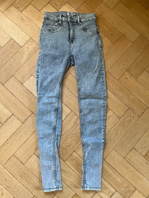 Grå skinny jeans - Snygga grå skinny jeans från Lager 157 med hög midja och klassisk femficksdesign. Jeansen har en cool tvättad look och är tillverkade i stretchigt denim som sitter tight hela vägen ner. I modellen Snake, strl M.
