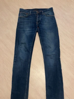 Nudie Jeans grim trim - Tja säljer dessa feta nudie jeans, har två hål vid bakfickorna, vanligt på dessa byxor men lappa dem o de e som nya. Köptes för 1600. Storlek 32/34 priset är inget som e hugget.