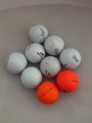 Golfbollar i vitt och orange - Säljer ett gäng golfbollar från Top Flite,Wilson och Callaway,åtta vita och två orange. Bollarna har klassisk dimple-design och är perfekta för dig som vill fylla på golfväskan. Passar både på banan och för träning.