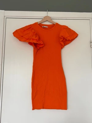 Orange kortklänning med volymärmar - Snygg orange kortklänning från Zara med ribbad struktur och stora volangärmar 