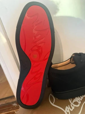 Svarta loafers från Christian Louboutin - Snygga svarta loafers från Christian Louboutin med den ikoniska röda sulan och diskret logga. Skorna är tillverkade i mocka och har en klassisk, stilren design som passar perfekt för dig som vill sticka ut. Medföljer originalpåse och autenticitetskort.