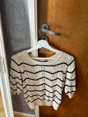 Glittrig stickad T-shirt  - Fin glittrig stickad T-shirt som sitter tajt. Liten i storleken. 