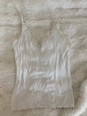 Vitt spetslinne - Vitt ribbat linne med snygga spetsdetaljer från Amisu i storlek M men jag skulle säga att det sitter som xs. Knappt använt