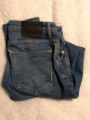 Blå jeans från Neuw - Snygga blå jeans från Neuw med klassisk femficksdesign och silverfärgade detaljer. Jeansen har en mörkblå tvätt och är tillverkade i ett slitstarkt denimtyg. Perfekta för dig som gillar en tidlös och enkel stil.