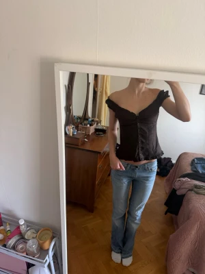 Brun offshoulder topp med knappar - Snygg brun offshoulder topp med knappar framtill och volangkant nertill. Helt ny 